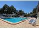 Large community pool surrounded by brick pavers, lounge chairs, tables, and lush landscaping offering shade at 11485 Oakhurst Rd # 319, Largo, FL 33774