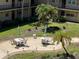 An overhead shot shows the community courtyard with outdoor seating including tables, chairs, and umbrellas at 11485 Oakhurst Rd # 319, Largo, FL 33774