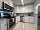 Bright kitchen featuring stainless steel appliances, granite countertops, and white cabinetry at 11485 Oakhurst Rd # 319, Largo, FL 33774