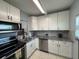 Well-lit kitchen features white cabinetry, granite countertops, stainless steel appliances and tile flooring at 11485 Oakhurst Rd # 319, Largo, FL 33774