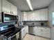 Updated kitchen features white cabinets, granite countertops, stainless steel appliances, and ample lighting at 11485 Oakhurst Rd # 319, Largo, FL 33774