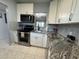 Updated kitchen features stainless steel appliances and gray granite countertops at 11485 Oakhurst Rd # 319, Largo, FL 33774