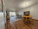 Living room with hardwood floors, ceiling fan, dining table, and sliding doors to a balcony at 11485 Oakhurst Rd # 319, Largo, FL 33774