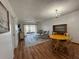 Comfortable living room with hardwood floors, dining table, and sliding doors to the balcony at 11485 Oakhurst Rd # 319, Largo, FL 33774