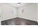 Clean bedroom with dark wood-look floors and two windows at 1204 Croydonwood Cir, Brandon, FL 33510