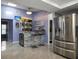 An elegant bar area adjacent to a modern kitchen with a wine fridge, a large stainless steel refrigerator at 13528 Woodside Dr, Hudson, FL 34667