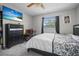 Cozy bedroom featuring a large window, dark furniture, and a ceiling fan at 13528 Woodside Dr, Hudson, FL 34667