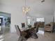 Dining room showcasing a glass table, chandelier lighting and bar area in the background at 13528 Woodside Dr, Hudson, FL 34667