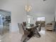 Stylish dining room with modern table, chairs, chandelier, and marble floors at 13528 Woodside Dr, Hudson, FL 34667