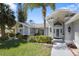 Inviting exterior view of a single-story home with manicured lawn and lush tropical landscaping at 13528 Woodside Dr, Hudson, FL 34667