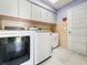 Well-lit laundry room equipped with cabinetry and modern washer and dryer at 13528 Woodside Dr, Hudson, FL 34667