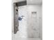 Shower boasts marble tile, with a multi-setting shower system and built-in niche for storage in this renovated modern bathroom at 13528 Woodside Dr, Hudson, FL 34667