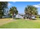 Corner lot shows the home exterior and side yard with large shade trees and landscaping at 13528 Woodside Dr, Hudson, FL 34667