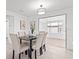 Open dining room with bright light, table seating for four, and views of the sunroom at 1499 Janet Pl, Englewood, FL 34223