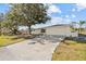 A well-maintained single-story home is showcased with a large driveway and a manicured lawn, providing ample space at 1499 Janet Pl, Englewood, FL 34223