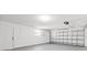 Garage featuring garage door, utility door, and painted floor at 1499 Janet Pl, Englewood, FL 34223