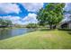 Serene backyard with lush green grass and beautiful water views at 150 James Ct, Oldsmar, FL 34677