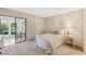 Neutral bedroom with glass door entry to lanai overlooking tranquil pond at 150 James Ct, Oldsmar, FL 34677