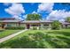 Well-maintained one-story home features lush green lawn, sidewalk, and manicured shrubs at 150 James Ct, Oldsmar, FL 34677