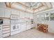 Bright white kitchen with modern appliances, a breakfast nook, and a decorative tray ceiling at 150 James Ct, Oldsmar, FL 34677