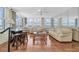 Bright living room with hardwood floors, comfortable seating, and stunning water views from the floor-to-ceiling windows at 17408 Gulf Blvd # 1302, Redington Shores, FL 33708