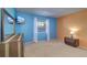 Comfortable bedroom with bright blue accent wall, light carpet, and window with white curtains at 200 Glennes Ln # 205, Dunedin, FL 34698