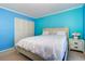 Bright bedroom featuring large closet space, comfortable bed, and bright blue walls at 200 Glennes Ln # 205, Dunedin, FL 34698