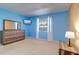 Light-filled bedroom boasting a blue accent wall, soft carpet, and ample natural light from a window at 200 Glennes Ln # 205, Dunedin, FL 34698