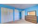 Bright bedroom with modern furniture, blue accent wall, plush carpeting, and well-lit closet space at 200 Glennes Ln # 205, Dunedin, FL 34698