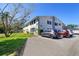 Condo exterior featuring building number 200, well-maintained landscaping, and convenient parking spaces at 200 Glennes Ln # 205, Dunedin, FL 34698