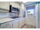 Clean kitchen with white cabinets, modern appliances, and view of outdoor patio at 200 Glennes Ln # 205, Dunedin, FL 34698