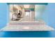 The kitchen pass-through features light granite counters and white cabinetry at 200 Glennes Ln # 205, Dunedin, FL 34698