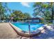 Community pool showcasing a clean and inviting atmosphere surrounded by trees and lounge seating at 200 Glennes Ln # 205, Dunedin, FL 34698