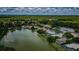 An aerial view shows lakeside homes surrounded by lush trees and a blue, cloudy sky at 2042 Diamond Ct, Oldsmar, FL 34677