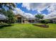 Well-manicured backyard featuring a screened pool area with mature landscaping at 2042 Diamond Ct, Oldsmar, FL 34677