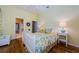 Cheerful bedroom featuring a bed with floral bedding, hardwood floor, and ensuite bathroom at 2042 Diamond Ct, Oldsmar, FL 34677