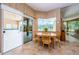 The breakfast nook includes a round wooden table, sliders to the pool, and a large window at 2042 Diamond Ct, Oldsmar, FL 34677
