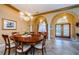 Elegant dining room features a round wood table, chandelier lighting, and arched entryway at 2042 Diamond Ct, Oldsmar, FL 34677