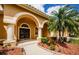 Front porch with an arched entryway, double doors, and palm trees in the front yard at 2042 Diamond Ct, Oldsmar, FL 34677