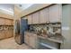 The kitchen features stainless steel refrigerator, light wood cabinets, mosaic tile backsplash, and a desk area at 2042 Diamond Ct, Oldsmar, FL 34677