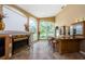 Cozy living space featuring a fireplace, wet bar, and large windows with views of the lush green outdoors at 2042 Diamond Ct, Oldsmar, FL 34677
