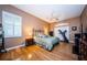This main bedroom features a ceiling fan, hardwood floors, and an entertainment center at 2042 Diamond Ct, Oldsmar, FL 34677