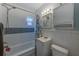Cozy bathroom features a shower over tub and a cabinet above the toilet for storage at 2639 28Th N Ave, St Petersburg, FL 33713