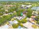Aerial view showing a home with solar panels and a screened-in pool, nestled in a lush, green neighborhood at 2671 Clubhouse N Dr, Clearwater, FL 33761