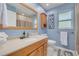 Bathroom featuring wood vanity with a large mirror, wood trim, and blue walls at 2671 Clubhouse N Dr, Clearwater, FL 33761
