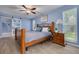 Cozy bedroom with a wooden bed frame, blue accent wall, ceiling fan, and natural light at 2671 Clubhouse N Dr, Clearwater, FL 33761