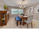 Inviting dining room featuring a wooden table, upholstered chairs, bench seating and modern chandelier at 2671 Clubhouse N Dr, Clearwater, FL 33761