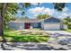 Charming home featuring a two-car garage, well-manicured lawn, and a welcoming facade at 2671 Clubhouse N Dr, Clearwater, FL 33761