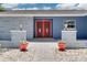 Inviting front entrance with double red doors, tasteful landscaping, and decorative flower pots at 2671 Clubhouse N Dr, Clearwater, FL 33761