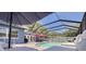 The backyard boasts a screened-in pool area, brick pavers, outdoor seating, and a view of the home's exterior at 2671 Clubhouse N Dr, Clearwater, FL 33761